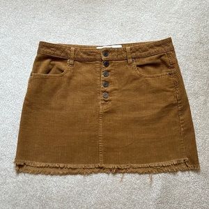 Corduroy button fly mini skirt with raw hem and working pockets.
